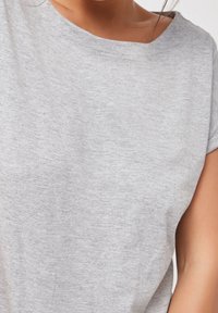 Grå kortærmet t-shirt lavet af blødt, struktureret stof med en afslappet pasform og bred halsudskæring. Ingen mønstre eller synlige hardware-detaljer.