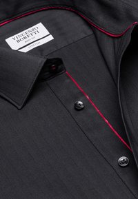 Camicia nera a motivo herringbone con cuciture di accentuazione rosse, dotata di colletto, pattina con bottoni e bottoni neri, etichettata "Vincenzo Boretti."