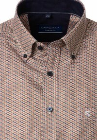 Męska koszula z guzikiem, z pomarańczowym, niebieskim i brązowym geometrycznym wzorem, z zapięciem na kołnierzyku oraz metką "Casa Moda Comfort Fit" wewnątrz kołnierza.