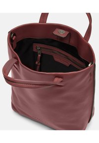 Sac fourre-tout en cuir rouge avec une texture lisse et des poignées supérieures. Comprend une poche zippée intérieure et une fermeture à pression en haut.