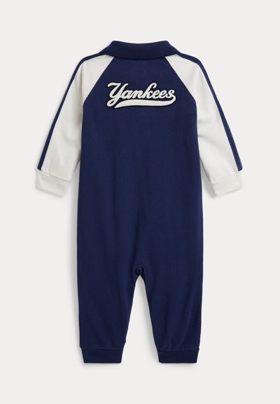 Granatowo-biały, długi rękaw niemowlęcego kombinezonu z wyhaftowanym na plecach napisem "Yankees" oraz ściągaczami przy mankietach i kołnierzu.