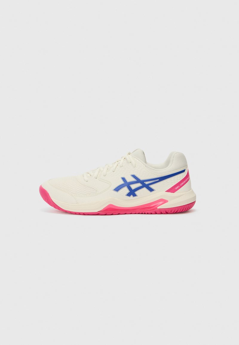 Sneaker i krem med mesh-overdel, blått logo og rosa yttersåle. Har teksturert stoff, snøring og polstret krave for komfort.
