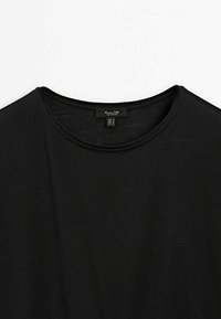 Sort T-shirt med korte ærmer og rund halsudskæring, lavet af blødt og letvægtsstof. Har et mærke syet ved halsen.