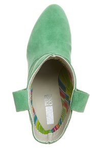 Bottine en daim vert à bout pointu avec détail élastique. L'intérieur présente un motif rayé coloré, ajoutant un contraste visuel.