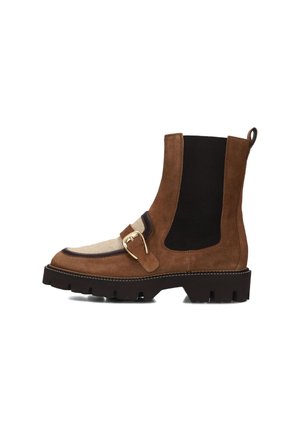 Bruine suede enkellaars met zwarte elastische panelen, ronde neus en een gouden gespaccent. Geribbelde zool met contrasterende stiksels.