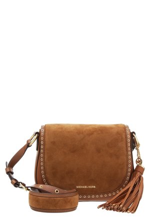 Brun ruskind crossbody-taske fra Michael Kors med gyldne øjenletdetaljer, justerbar rem og læderkvast vedhæng på hvid baggrund.