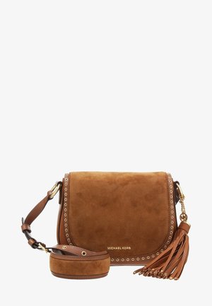 Bolso bandolera marrón de ante de Michael Kors con detalles de ojales dorados, correa ajustable y adorno de borla de cuero sobre fondo blanco.