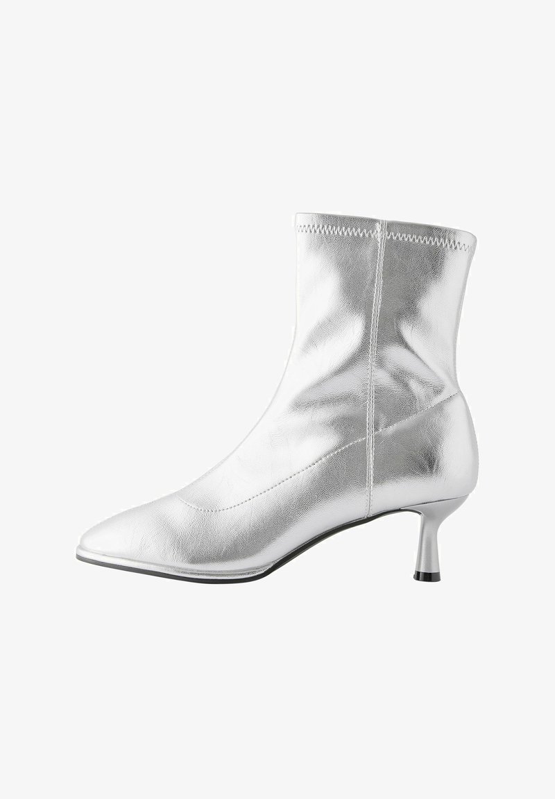 Bottine argentée en cuir métallique brillant, avec un bout pointu, une texture lisse et un talon kitten de 5 cm.