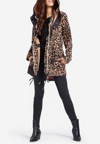 Luipaardprint parka-jas met een rits, trekkoord in de taille, capuchon en zijzakken. Zwarte accenten op de kraag en manchetten.