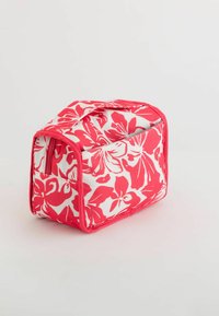 Suuri kosmetiikkalaukku, jossa on vaaleanpunaisia ja valkoisia kukkamalleja. Laukussa on vetoketjullinen suljenta ja kestävä kahva, joka helpottaa kantamista.