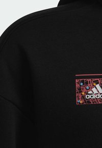 Czarny sweatshirt z kwadratową grafiką w kolorze czerwonym, z białym logo Adidas i kolorowymi kropkami, wyróżniający się teksturowanym, miękkim materiałem.
