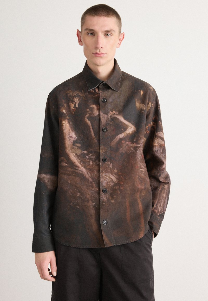Chemise à boutonnage comportant un tissu texturé foncé avec un design pictural. Les couleurs incluent des tons marron et des nuances atténuées, avec six boutons sur le devant.