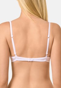 Reggiseno bianco senza cuciture con spalline regolabili, tessuto morbido e chiusura con ganci sul retro. Texture liscia e design minimalista.