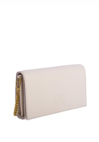 Bolso de mano rectangular en color crema con cierre de solapa, logo sutil en relieve y correa de cadena dorada unida a un lado.