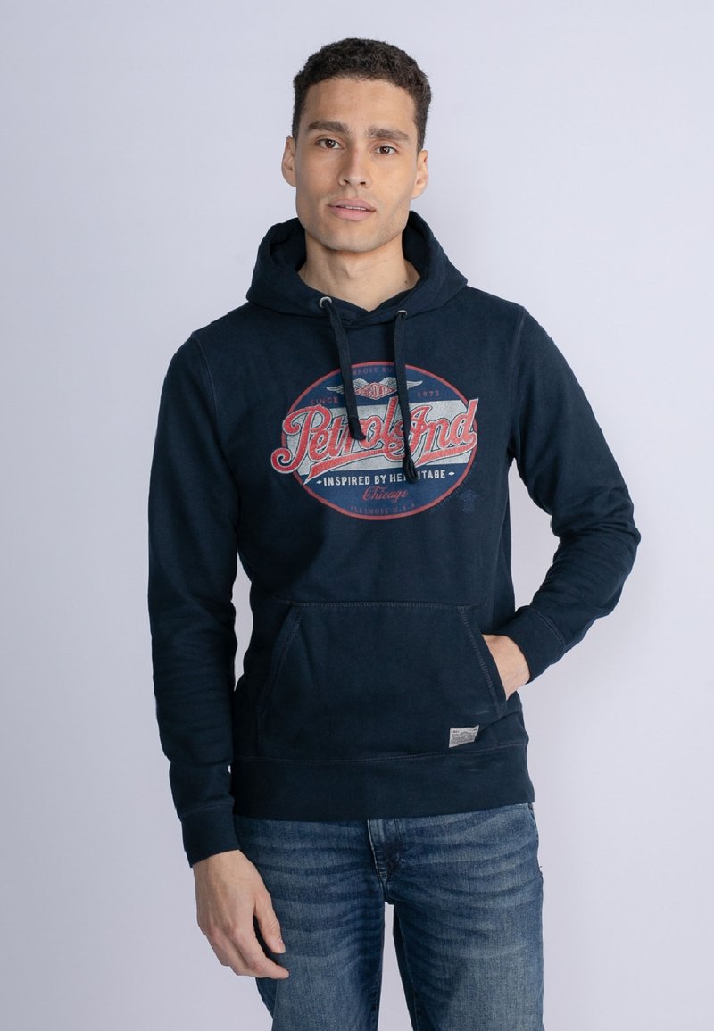 Marineblauwe hoodie van katoenmix, met een grote grafische print aan de voorkant, trekkoorden en een kangoeroezak. Klassieke pasvorm met ribgebreide boorden.