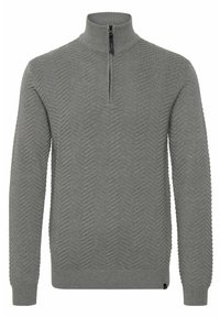 Suéter de color gris claro con cuello alto y cremallera de cuarto, que presenta un patrón de zigzag texturizado en toda la tela y puños acanalados.