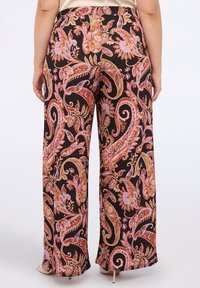 Široké kalhoty v černé látce s barevným paisley vzorem, který obsahuje květinové prvky v růžové, oranžové a fialové barvě. Elastický pas.