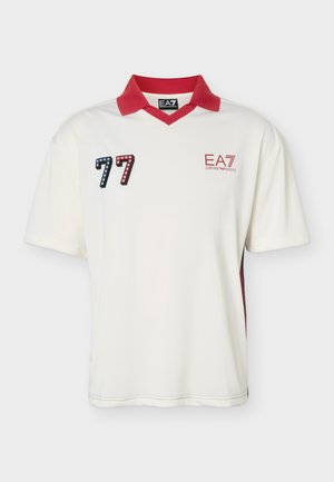 Polo blanc à manches courtes avec col rouge, écusson "77" à motif étoilé rouge et bleu, et logo rouge "EA7 Emporio Armani" sur la poitrine.