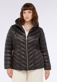 Giubbotto nero imbottito con motivo a zig zag, dotato di cappuccio, chiusura con zip e pannelli laterali testurizzati. Materiale liscio e lucido.