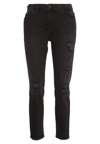 Jeans ajustados negros de mezclilla con áreas desgastadas en las rodillas. Diseño clásico de cinco bolsillos con cierre de cremallera y botón.