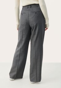 Grijze op maat gemaakte broek met een recht model, voorzien van twee achterzakken en subtiele textuur. Draagt men met witte sneakers.