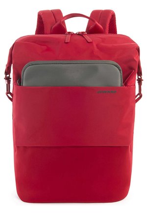 Zaino rosso realizzato in tessuto resistente. Presenta una tasca frontale con una manica grigia per laptop, spallacci imbottiti e una maniglia superiore per il trasporto.