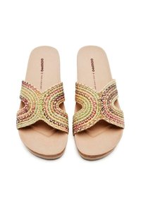 Sandalias deslizantes tejidas con un diseño de tiras cruzadas asimétricas en colores pastel. Plantilla suave y acolchada con detalles texturizados.
