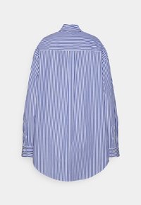 Camicia a maniche lunghe blu e bianca a righe con colletto button-down, caratterizzata da un orlo dritto sul retro e dettagli con bottoni sulle maniche.