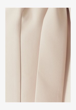 Tissu beige clair avec une surface lisse et texturée, présentant de multiples plis et creases pour un effet de drapé nuancé.