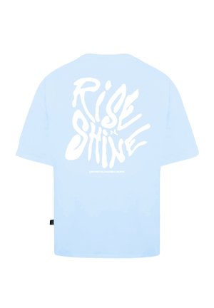 T-shirt bleu clair avec des lettres blanches audacieuses au dos, indiquant "RISE & SHINE". Coupe standard avec des manches courtes et un tissu doux.