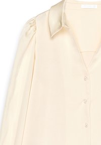 Cream blouse with a satin collar, button front, and puffed sleeves. Smooth texture and a tailored fit with subtle sheen.