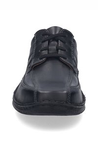 Černá kožená bota s hladkým povrchem, která se vyznačuje nízkým designem, šněrovacím systémem, kontrastním prošíváním a zaoblenou špičkou.