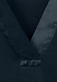 Donker marineblauwe top met een V-hals ontwerp. De halslijn heeft een gladde satijnen rand, terwijl de hoofdstof een gestructureerde stof is.