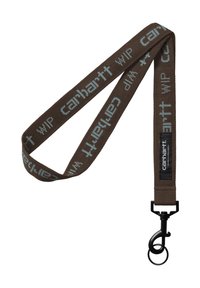 Cordón de tela marrón con texto "Carhartt WIP" en azul claro. Cuenta con un clip metálico negro para sujeción y una superficie texturizada.