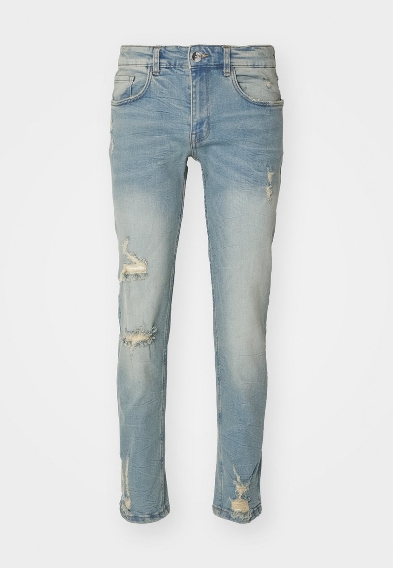 Jeans skinny desgastados de color azul claro con desvanecidos y rasgaduras desgastadas en los muslos delanteros y en la parte inferior de las piernas, con cierre de botón y cremallera, y trabillas para cinturón.
