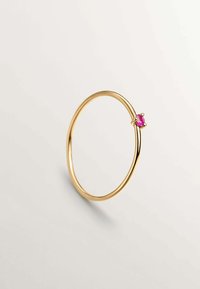 Anillo de oro con una banda delgada y lisa que presenta una pequeña piedra rosa engastada en un ajuste de garra. Diseño simple y minimalista.
