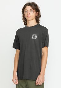 Sort bomulds T-shirt med korte ærmer, en afslappet pasform og et grafisk print i en kvadratisk ramme på venstre brystområde.