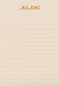 Superficie texturizzata color crema con righe orizzontali e logo metallico oro "ALDO" al centro in alto.