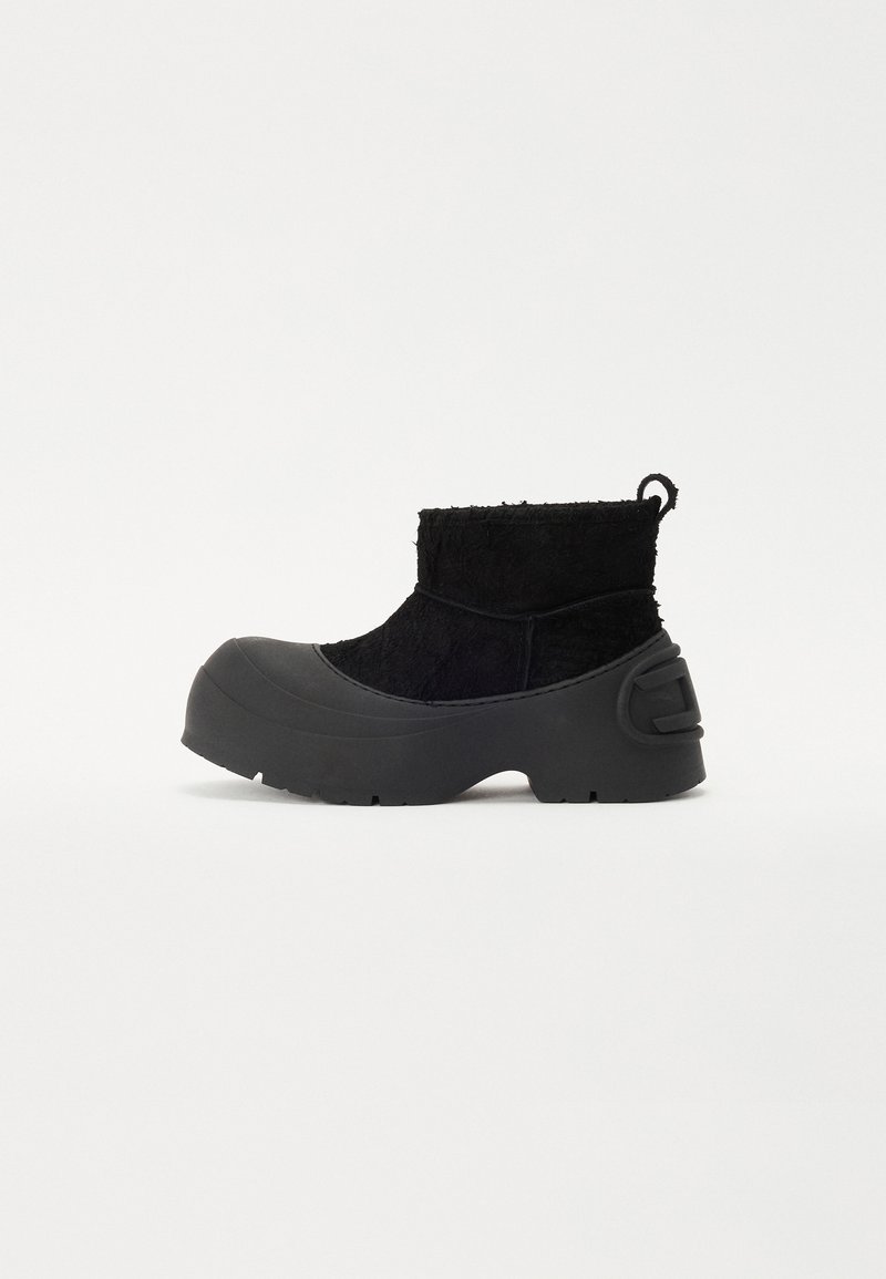 Black ankle boots with a textured upper and rubber front. Features a chunky sole and a loop for easy wear. Simple design with a matte finish.