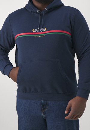 Sudadera color azul marino hecha de un tejido suave, con un bolsillo canguro en la parte delantera, capucha con cordón y detalles decorativos a rayas en rojo y verde.