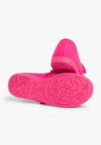 Zapatos de un brillante color rosa con parte superior de tela texturizada y suela de goma, adornados con divertidos patrones de corazones y flores en la parte inferior.
