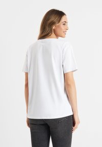 Witte korte mouwen t-shirt met een ronde halslijn, vervaardigd uit zachte katoen en subtiele merkaanduiding op de bovenrug.