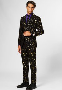 Black suit with gold festive patterns, including stars and celebratory items. Complemented by a purple shirt and black shoes.