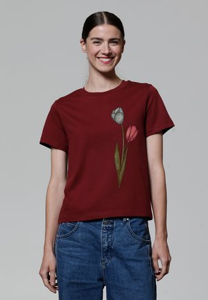 T-shirt court bordeaux en coton, avec un graphique de tulipe gris et rose sur le côté gauche, à manches courtes et col rond.