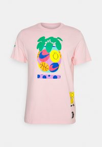 Camiseta de algodón rosa con un gran gráfico de piña con colores brillantes, caras sonrientes y balones de baloncesto, junto con acentos y logotipos de colores.