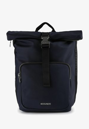 Mochila enrollable azul marino con bolsillo frontal con cremallera, correa negra con hebilla plateada y logotipo plateado "BOGNER" en el centro inferior.