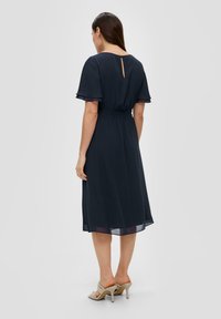 Donker marineblauw, knielang jurk met korte vlindermouwen, elastische taille en een sleutelgatdetail aan de achterkant; gemaakt van lichtgewicht, vloeiende stof.