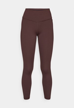 Leggings extensibles dans une couleur marron foncé, avec une taille haute, une texture lisse et sans motifs ni embellissements visibles.