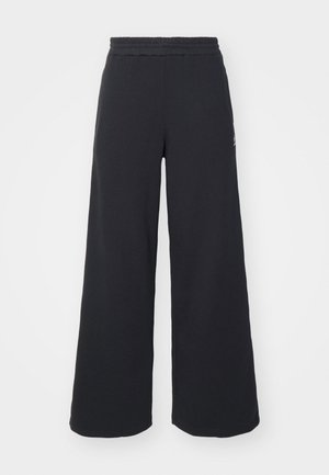 Pantalones de chándal negros de pierna ancha, hechos de una tela suave, con una cintura elástica y un pequeño logo en el lado izquierdo.