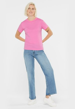 Short-sleeve pink T-shirt made of cotton, paired with light blue straight-leg jeans and white sneakers. Features a classic crew neck design.